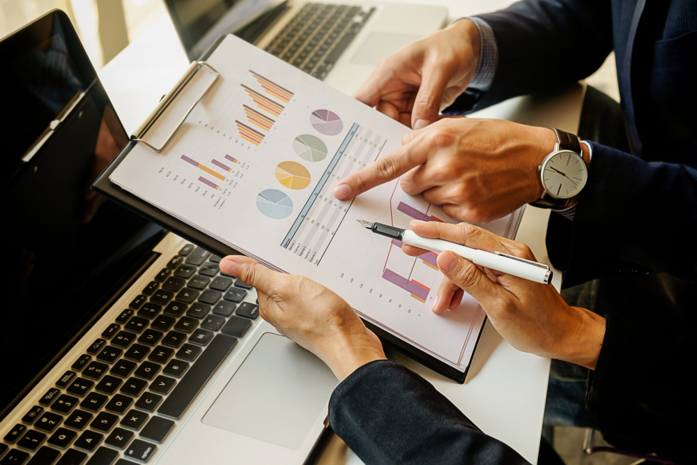 An image of back office employees auditing financial reports for insights
